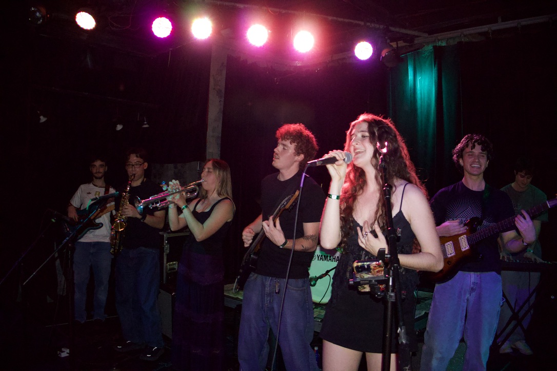 Olivia singing with the horn section behind her